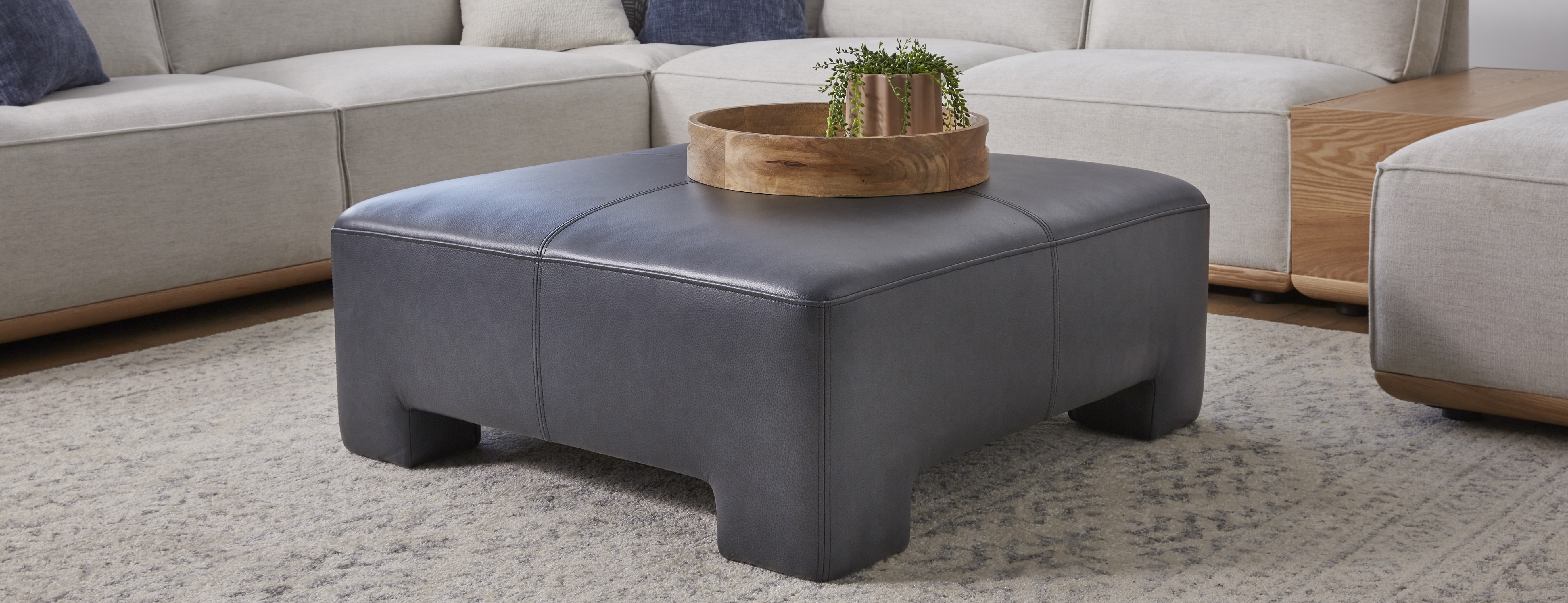 dark grey leather upholstered ottoman